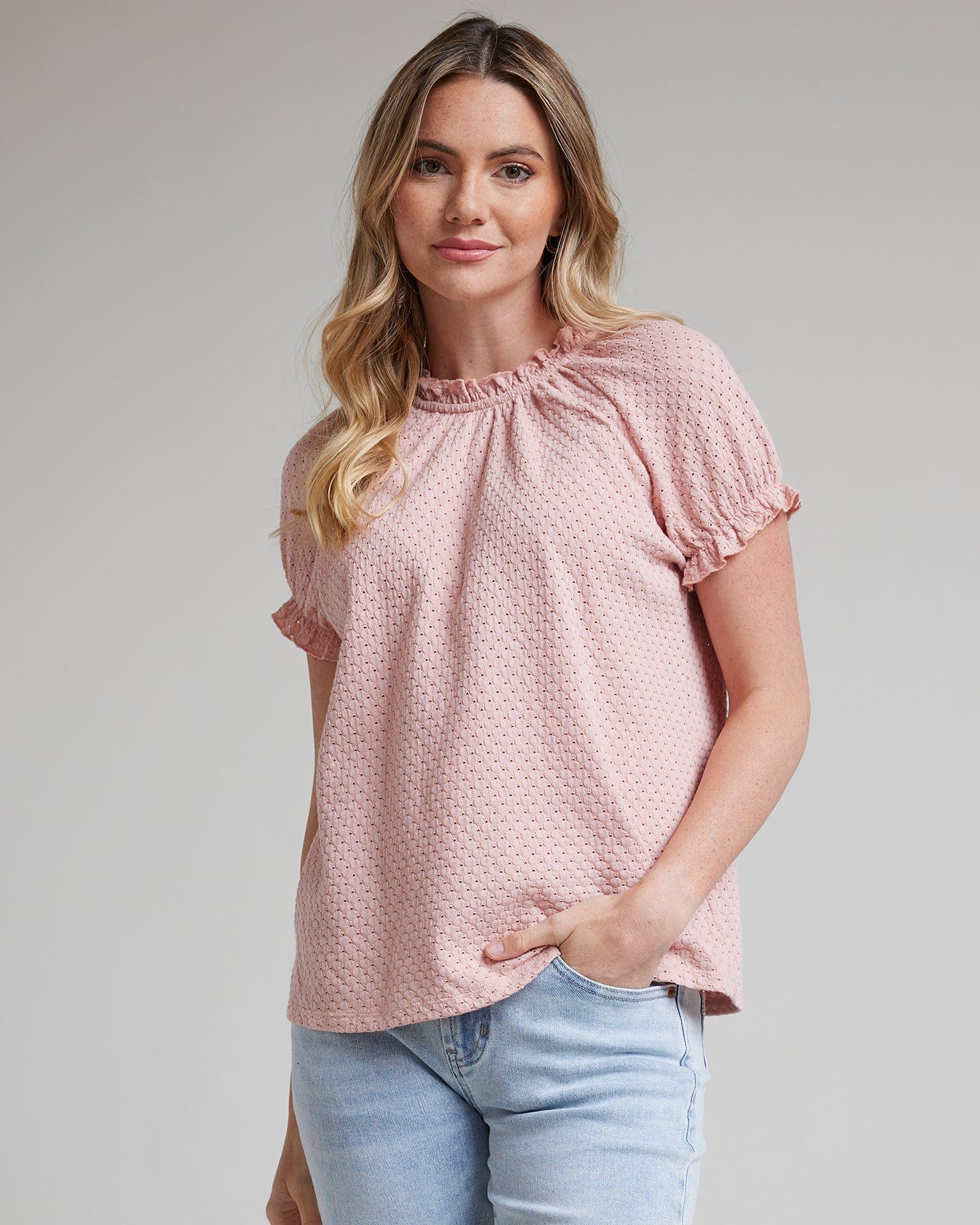 Woman in a short sleeve, mock neck with ruffles blouse