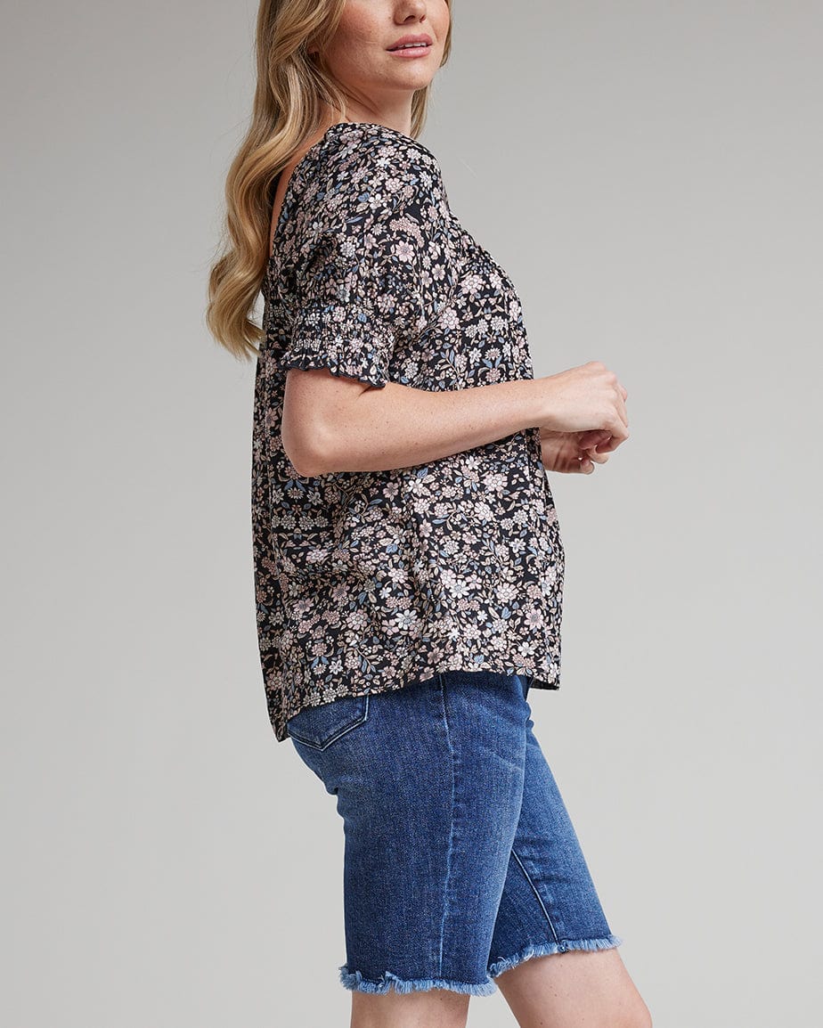 Woman in a floral printed, off the shoulder, short sleeve blouse