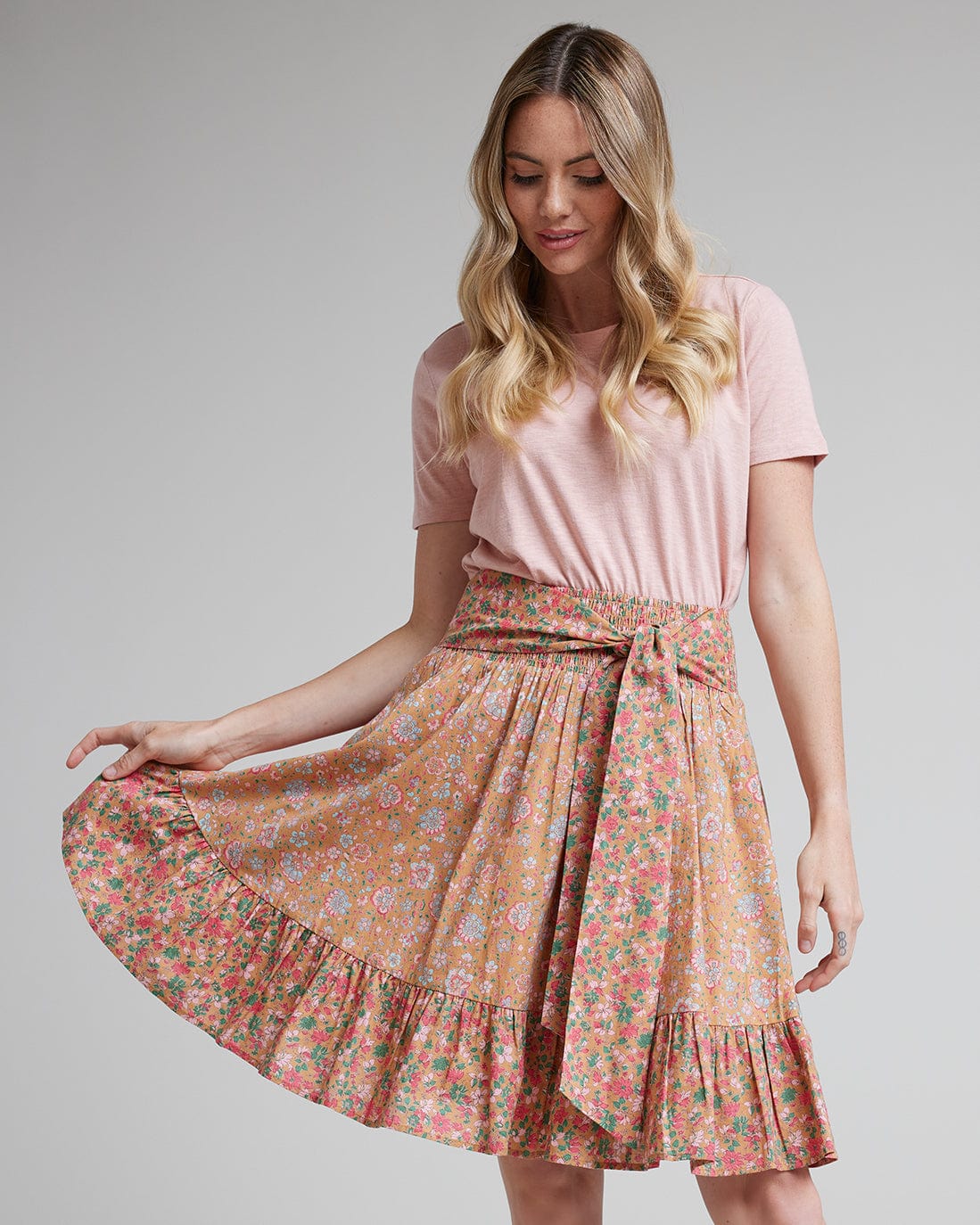 Woman in pink floral knee-length skirt