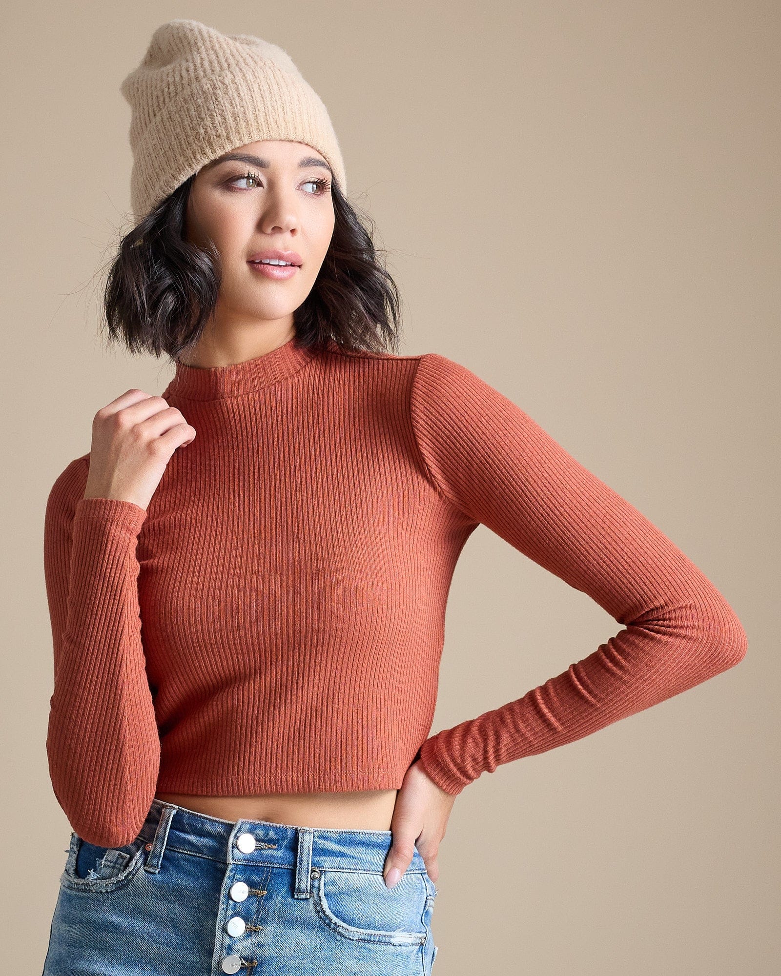 Woman in a burnt orange long sleeve ribbed cropped tee
