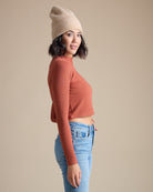 Woman in a burnt orange long sleeve ribbed cropped tee