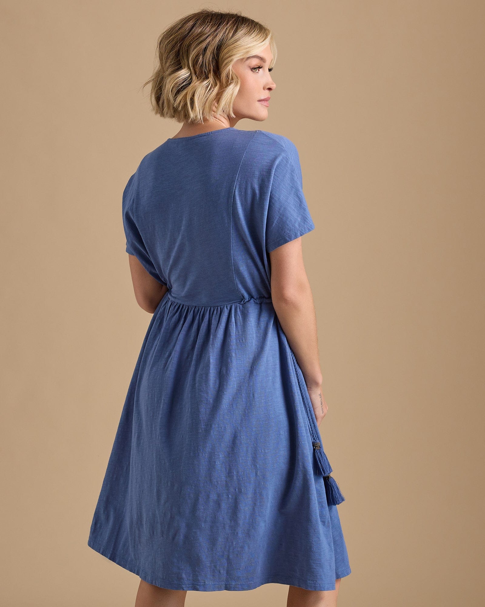 Woman in a short sleeve, pleated front, knee-length, blue drss