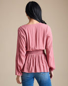 Woman in a pink long sleeve peplum blouse