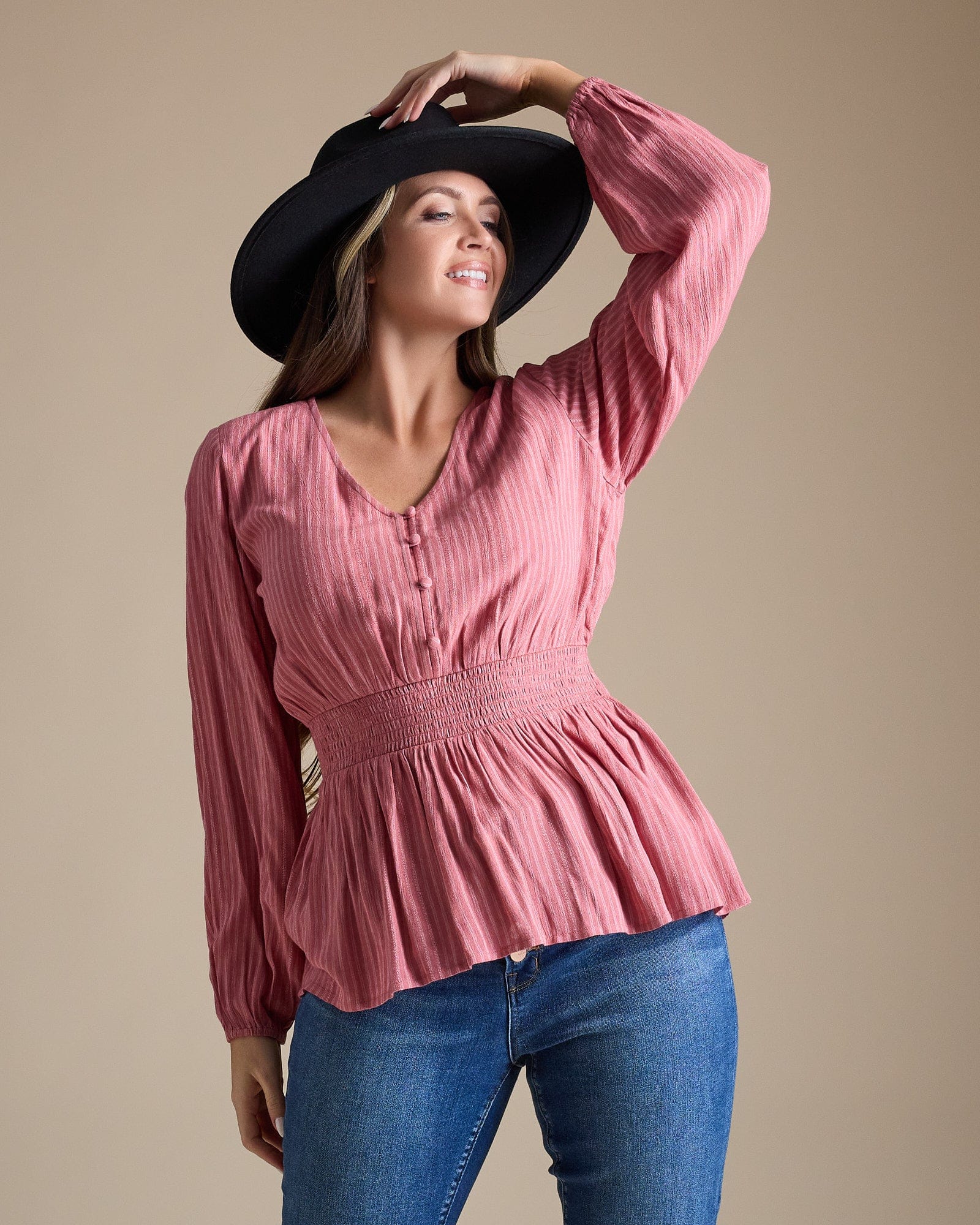 Woman in a pink long sleeve peplum blouse
