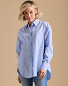 Woman in a light blue, vertical striped, collared button-down