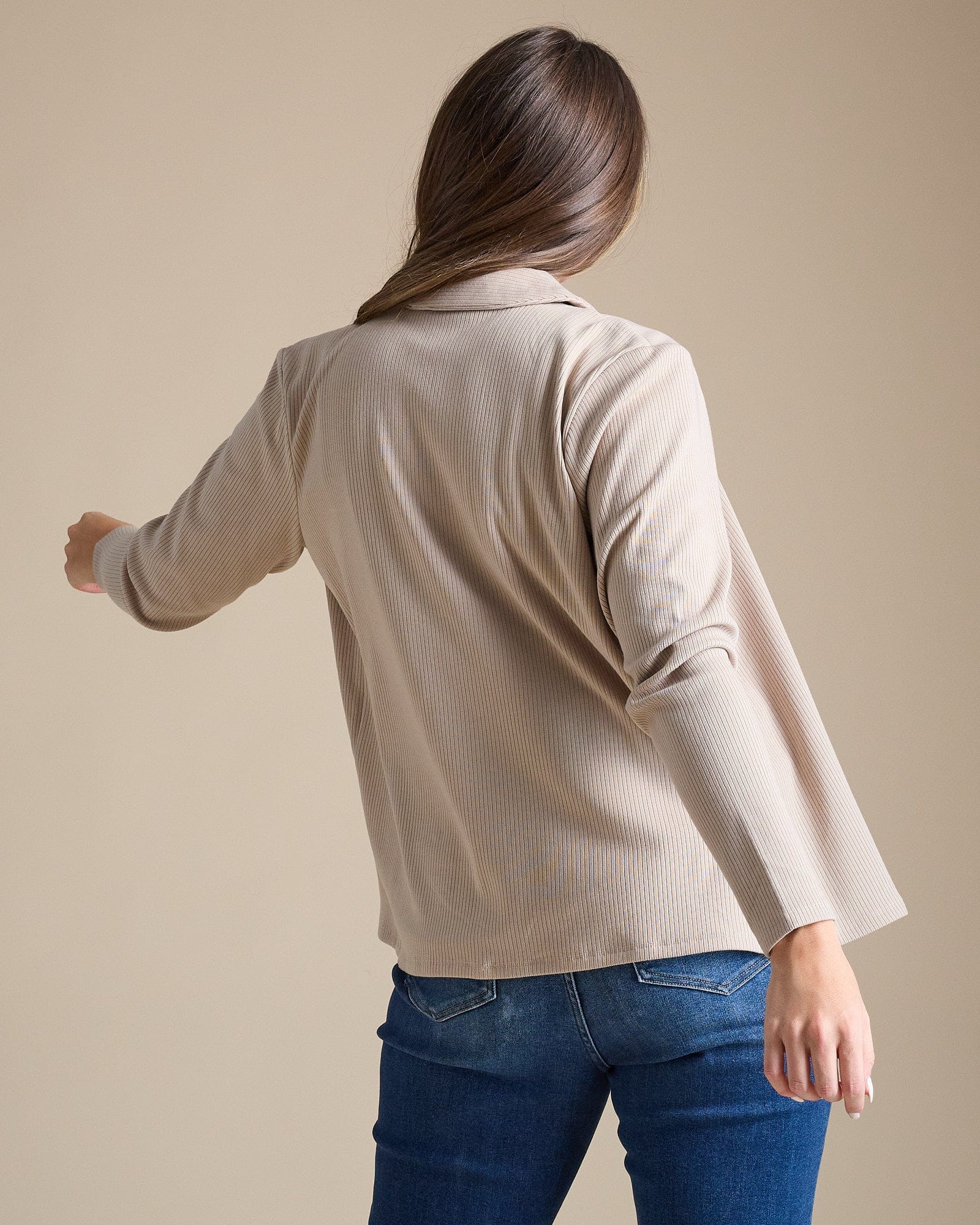 Woman in tan long sleeve collared cardigan