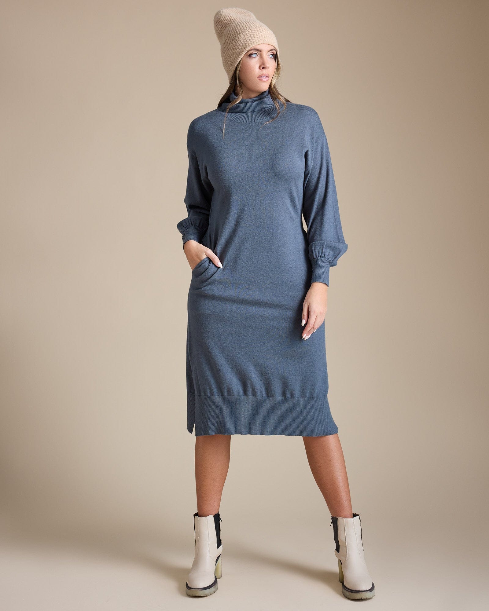 Woman in a long sleeve, midi-length, turtleneck, blue sweater dress